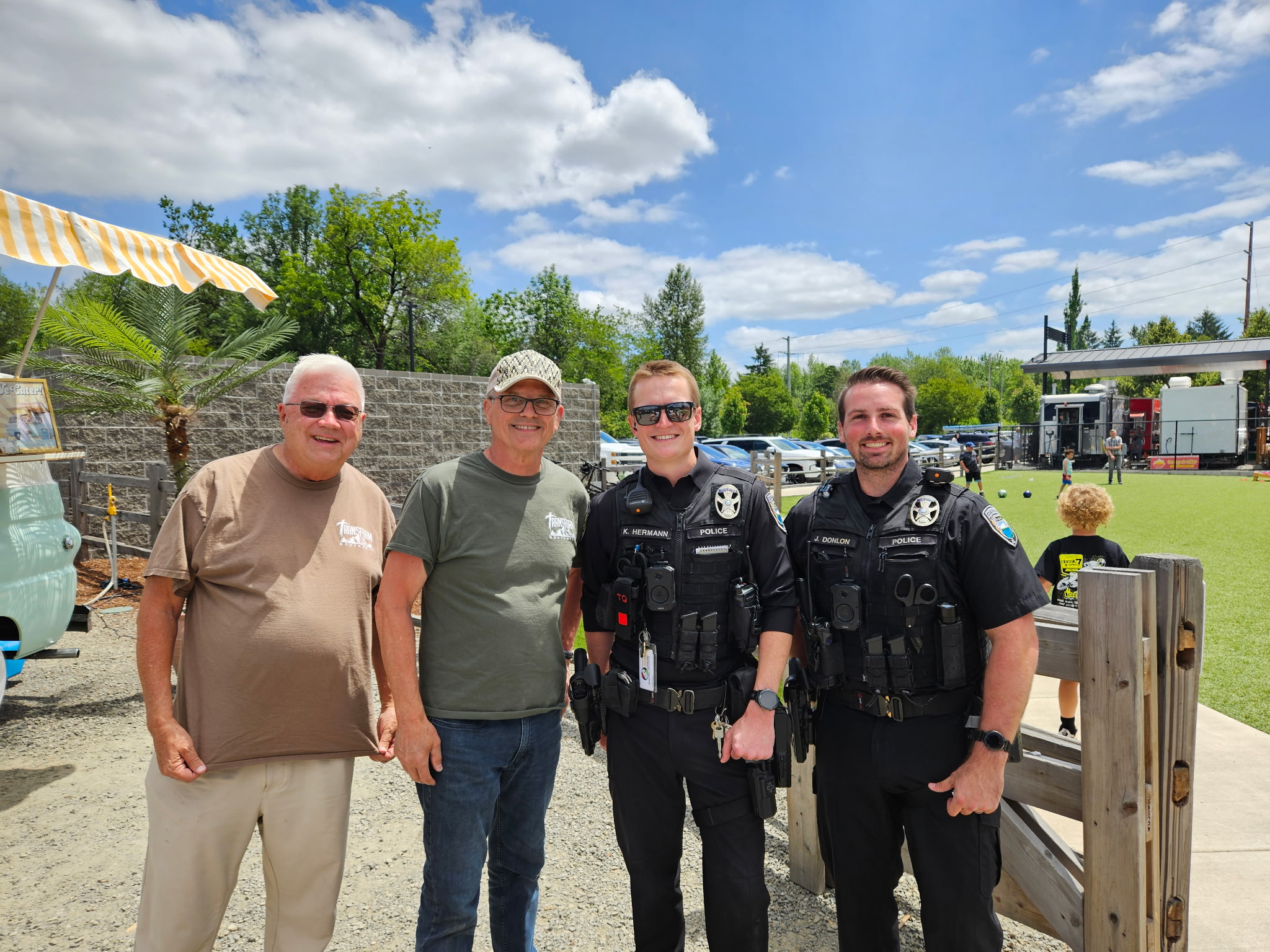 Transform Northwest volunteers standing with local police officers at Cops and Cones
